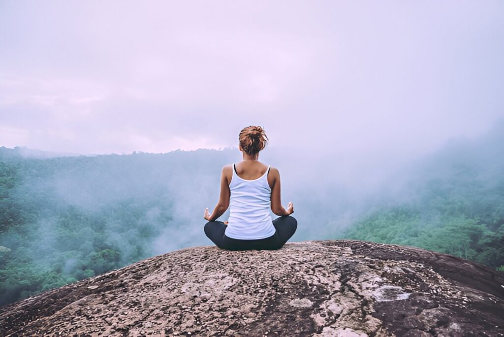 Asian women relax in the holiday. Play if yoga. On the Moutain rock cliff